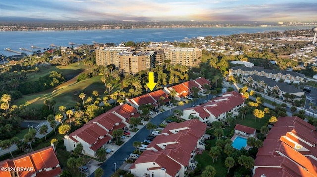 aerial view at dusk featuring a water view