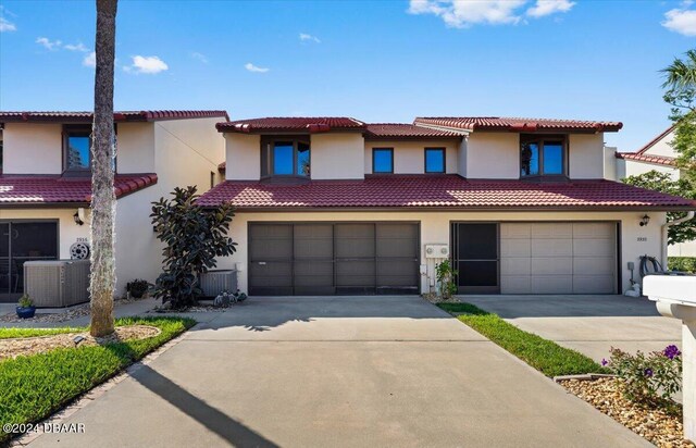 mediterranean / spanish-style home featuring a garage and central AC