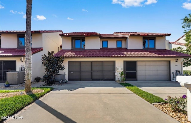 2934 Oceans Trce, Daytona Beach Shores, FL 32118 - view of front of home featuring stucco siding, a garage, concrete driveway, a tile roof, and central AC unit