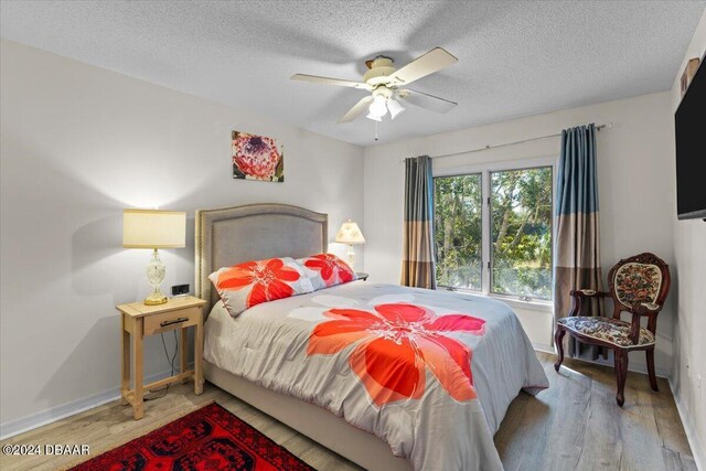 2934 Oceans Trce, Daytona Beach Shores, FL 32118 - bedroom with wood finished floors, a textured ceiling, baseboards, and a ceiling fan