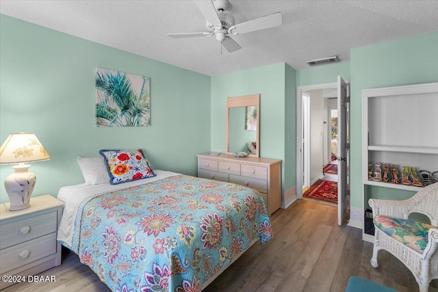 bedroom featuring wood-type flooring, ceiling fan, and a textured ceiling