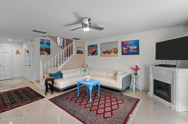 living room with a textured ceiling and ceiling fan