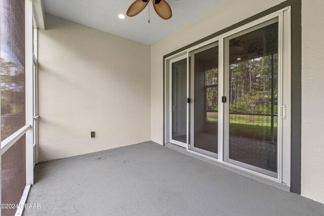 unfurnished sunroom with ceiling fan