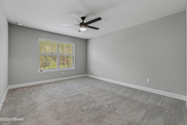 unfurnished room with ceiling fan, a textured ceiling, and light colored carpet