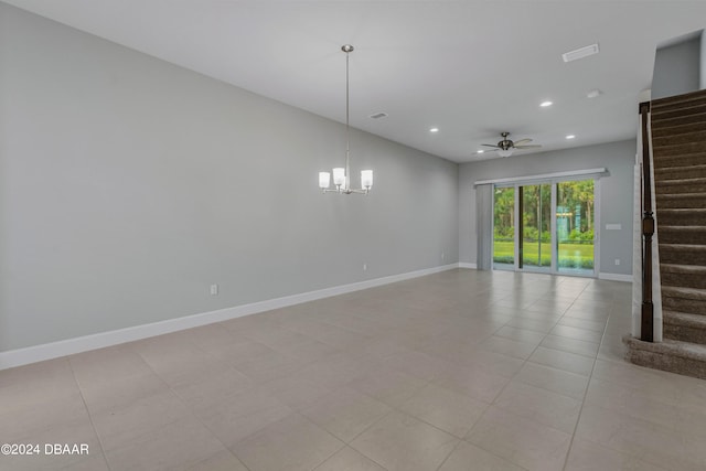 spare room with ceiling fan with notable chandelier and light tile patterned floors