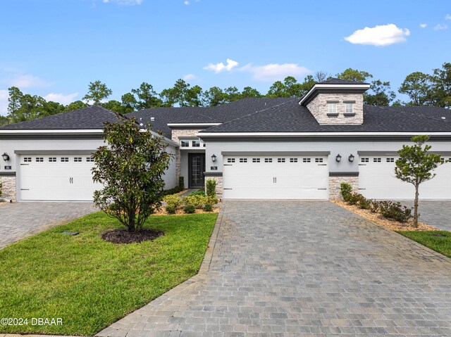 view of front of home with a front lawn and a garage