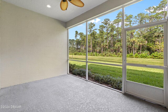 unfurnished sunroom featuring ceiling fan