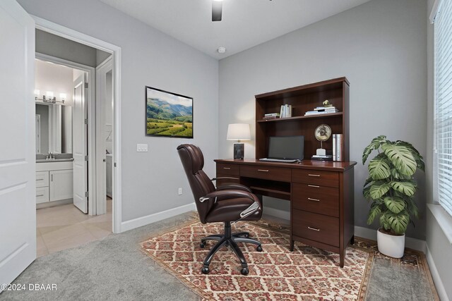 carpeted office space with sink and ceiling fan