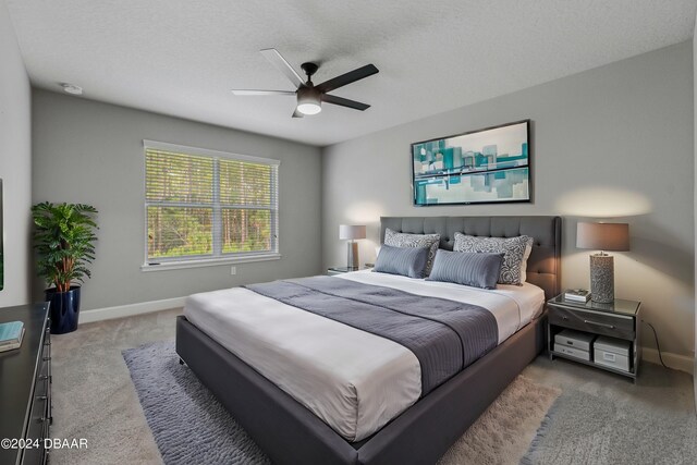 bedroom featuring ceiling fan, a textured ceiling, and carpet flooring