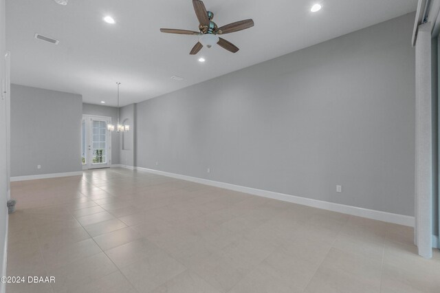 unfurnished room with ceiling fan with notable chandelier and light tile patterned floors