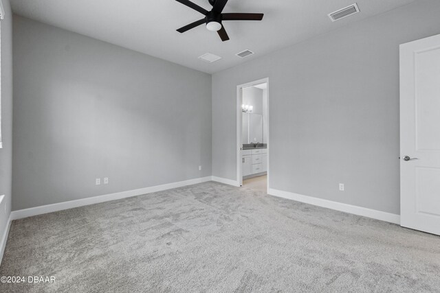 unfurnished bedroom featuring ensuite bathroom, ceiling fan, and light colored carpet