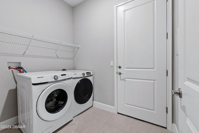 clothes washing area with light tile patterned floors and independent washer and dryer