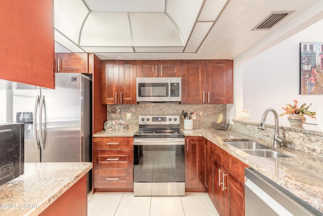 1237 Charter Oaks Cir, Holly Hill, FL 32117 - kitchen featuring appliances with stainless steel finishes, light stone countertops, light tile patterned floors, and decorative backsplash