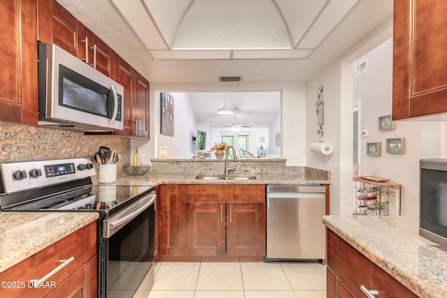 1237 Charter Oaks Cir, Holly Hill, FL 32117 - kitchen with stainless steel appliances, light tile patterned floors, a ceiling fan, decorative backsplash, and light stone countertops