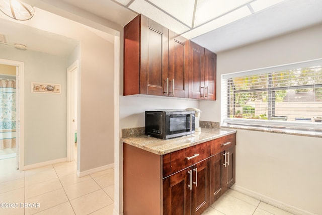1237 Charter Oaks Cir, Holly Hill, FL 32117 - kitchen with stainless steel microwave, light stone countertops, and light tile patterned flooring