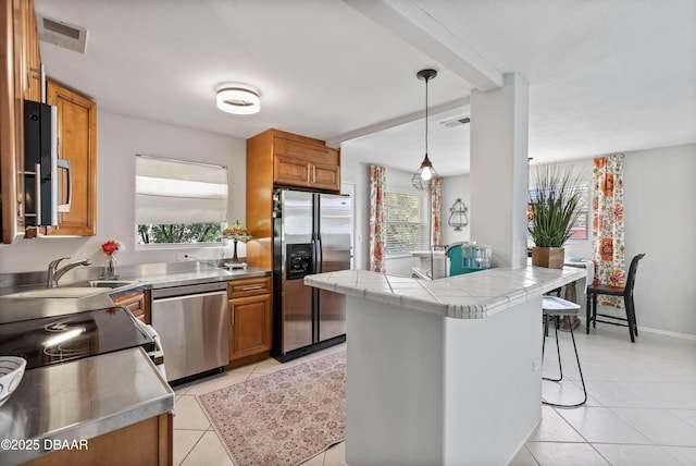 326 Flushing Ave, Daytona Beach, FL 32118 - kitchen featuring stainless steel appliances, brown cabinets, and healthy amount of natural light