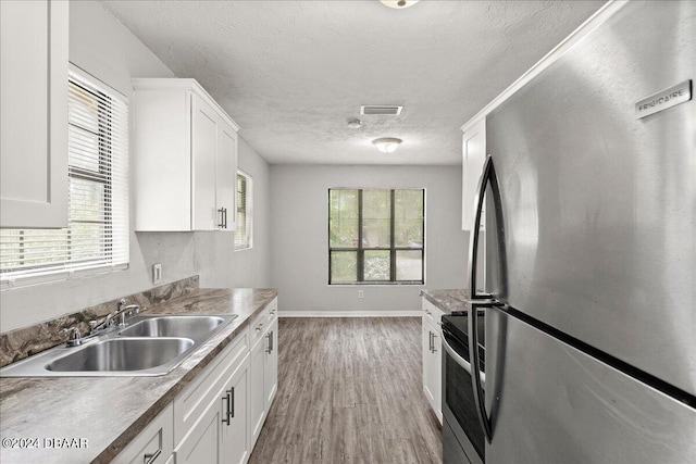 kitchen featuring white cabinetry, sink, a healthy amount of sunlight, and appliances with stainless steel finishes