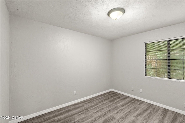 spare room with wood-type flooring and a textured ceiling