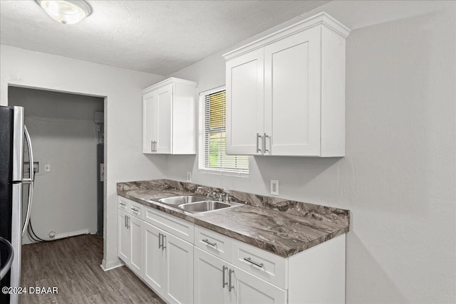 kitchen with white cabinets, a textured ceiling, sink, dark hardwood / wood-style floors, and stainless steel fridge