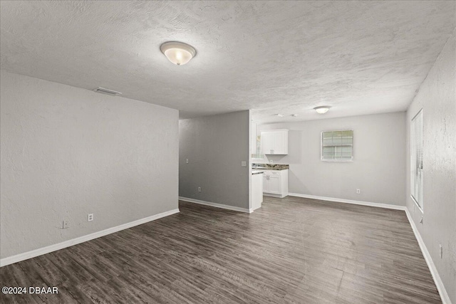 317 Reva St, Daytona Beach, FL 32114 - unfurnished living room featuring dark wood finished floors, a textured ceiling, and baseboards