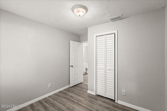 unfurnished bedroom featuring hardwood / wood-style flooring and a closet