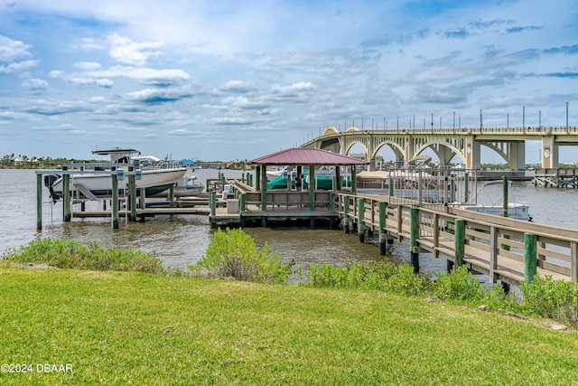 view of dock featuring a water view and a yard