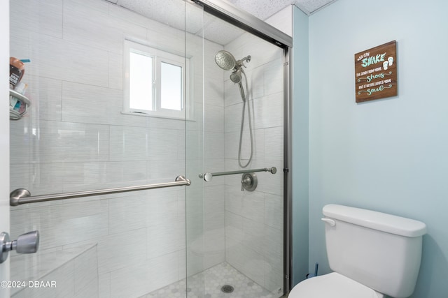 bathroom with toilet, a textured ceiling, and walk in shower