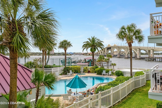 view of pool with a water view and a patio