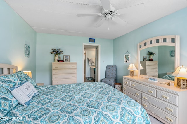 bedroom with ensuite bathroom, carpet floors, and ceiling fan