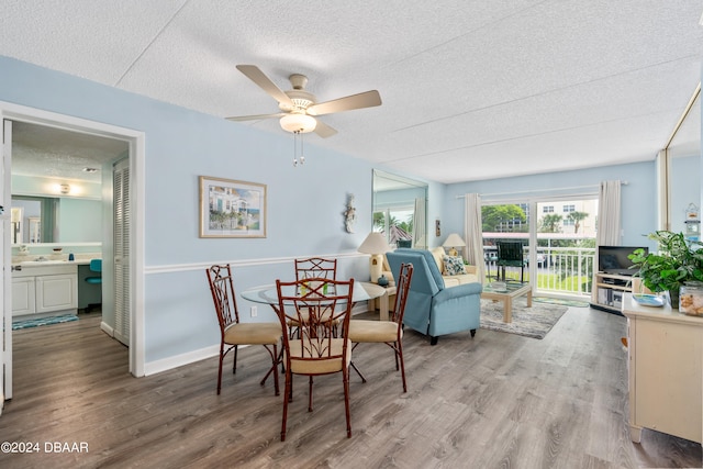 dining space with hardwood / wood-style flooring, ceiling fan, and a textured ceiling