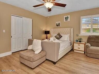 bedroom with light hardwood / wood-style flooring, a closet, and ceiling fan