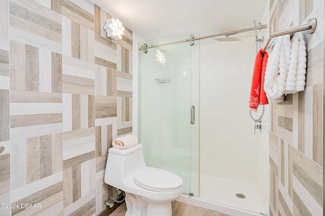 bathroom featuring walk in shower, toilet, and hardwood / wood-style flooring