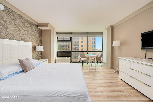 bedroom featuring light wood-type flooring and a wall of windows