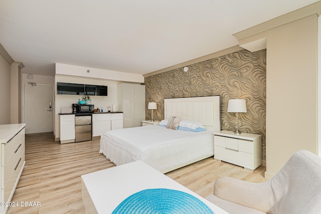 bedroom with light wood-type flooring and stainless steel refrigerator