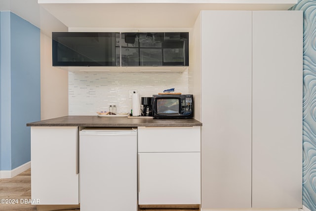 bar featuring white fridge, white cabinetry, backsplash, and light hardwood / wood-style floors