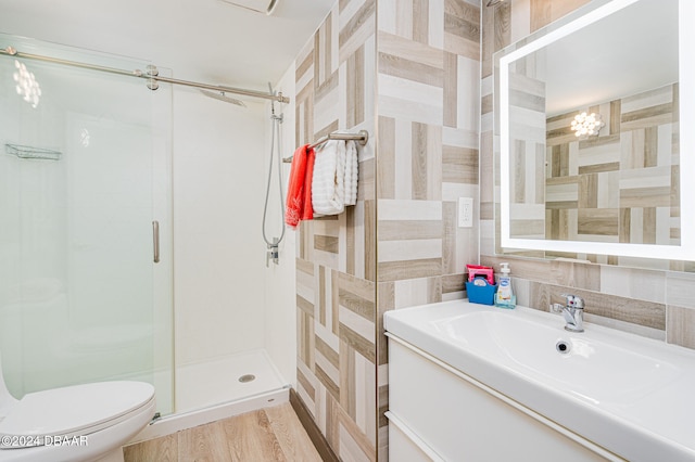 bathroom featuring toilet, hardwood / wood-style floors, a notable chandelier, an enclosed shower, and vanity