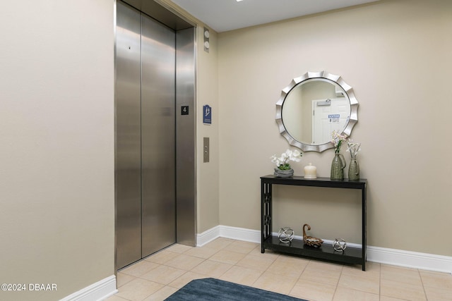 hall with elevator and light tile patterned flooring