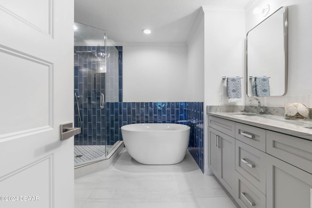 bathroom featuring tile walls, vanity, ornamental molding, and separate shower and tub