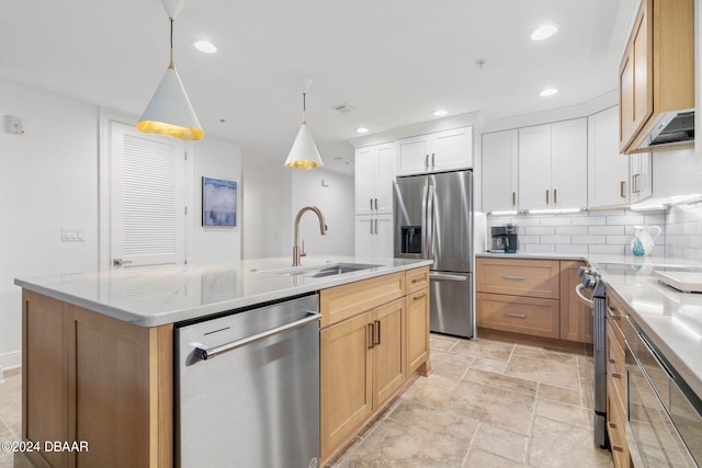 kitchen with stainless steel appliances, white cabinets, sink, a kitchen island with sink, and decorative light fixtures