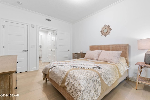 bedroom with light hardwood / wood-style floors and crown molding