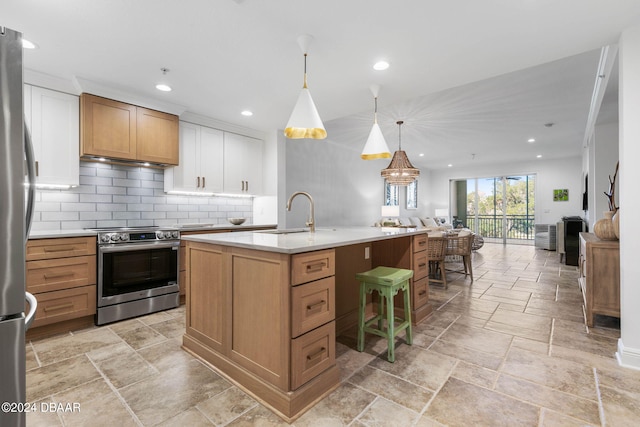 146 Palm Coast Resort Blvd Unit 409, Palm Coast, FL 32137 - kitchen featuring appliances with stainless steel finishes, a sink, open floor plan, stone tile flooring, and light countertops