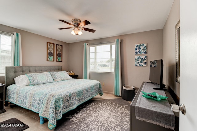 bedroom featuring multiple windows, ceiling fan, and light hardwood / wood-style flooring