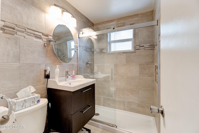 bathroom featuring toilet, vanity, an enclosed shower, and tile walls