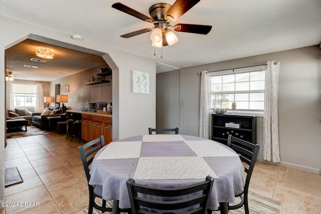 dining space with light tile patterned flooring and ceiling fan