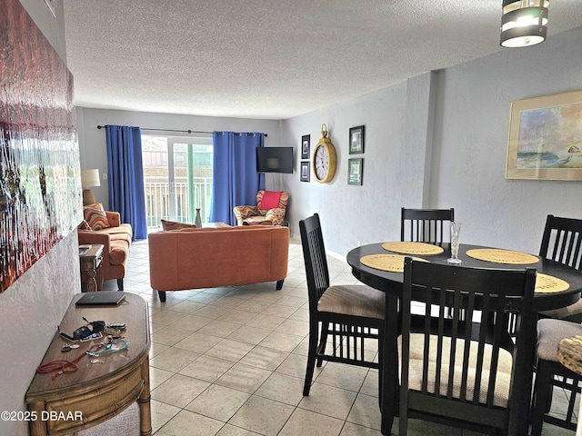 dining area with a textured ceiling and light tile patterned floors