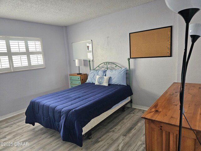 bedroom with hardwood / wood-style floors and a textured ceiling