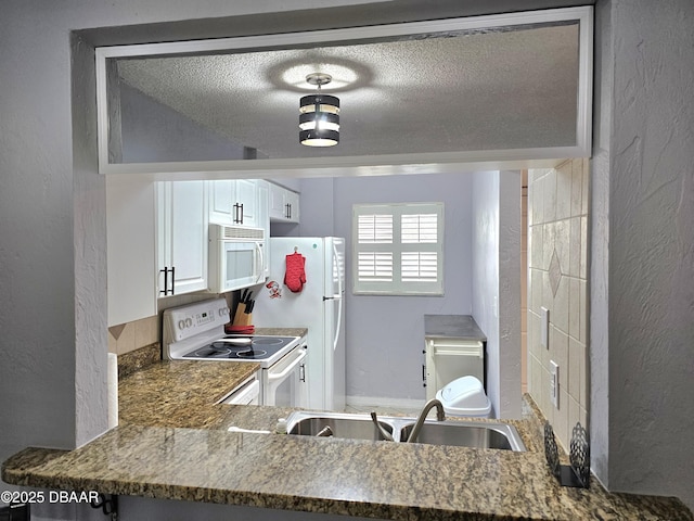 kitchen featuring white cabinetry, sink, white appliances, and a textured ceiling