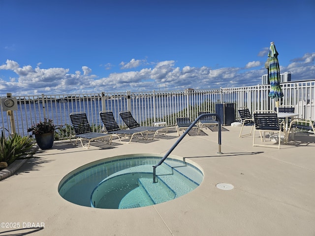 view of swimming pool featuring a water view, a hot tub, and a patio area