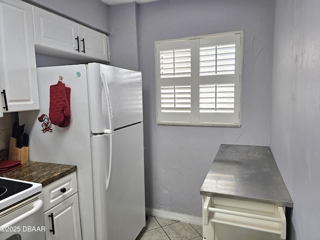 kitchen featuring white cabinetry, light tile patterned flooring, and white appliances