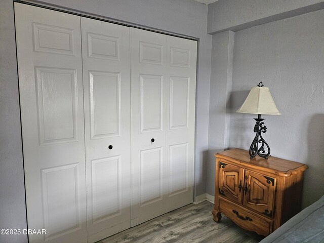 bedroom with light hardwood / wood-style flooring and a closet